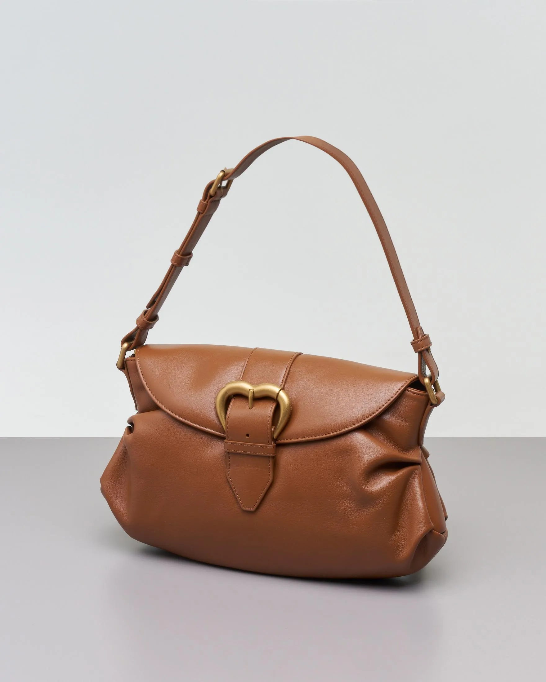 Classic Jolene Leather Bag in Tan with Heart-Shaped Gold Buckle Flap and Adjustable Shoulder Strap.